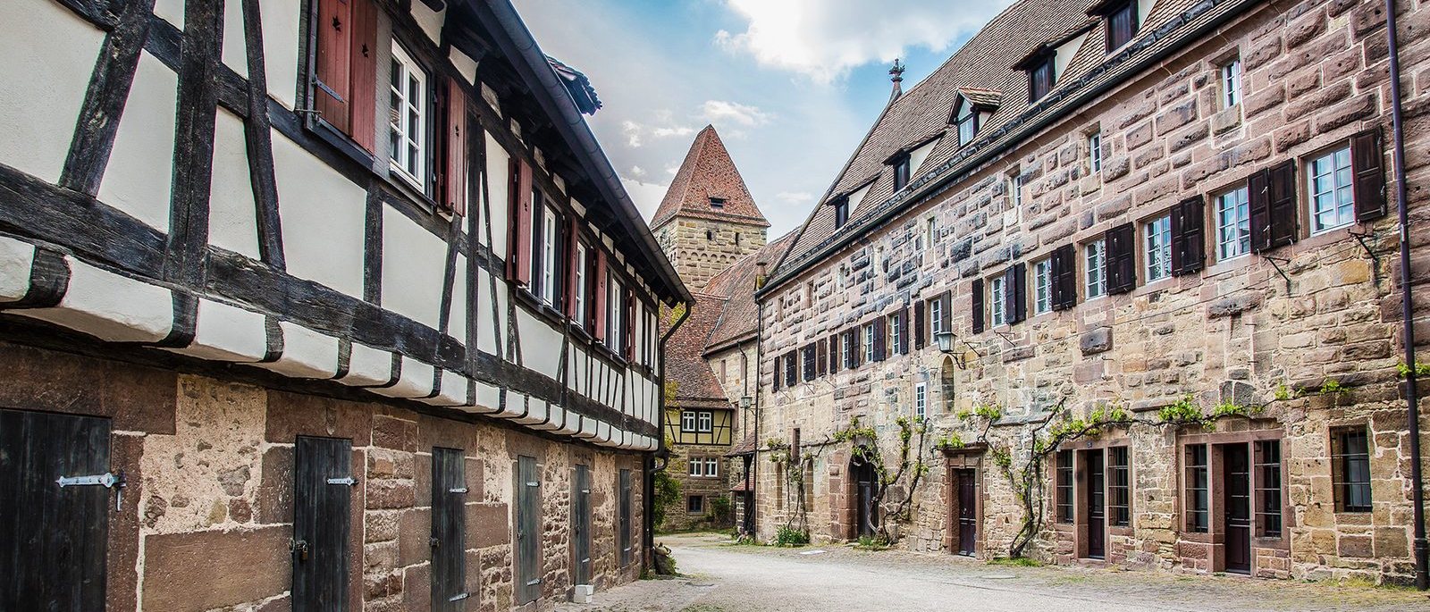 Gasse mit sanierten Fachwerkhäusern und farbig gefasstem Gebälk